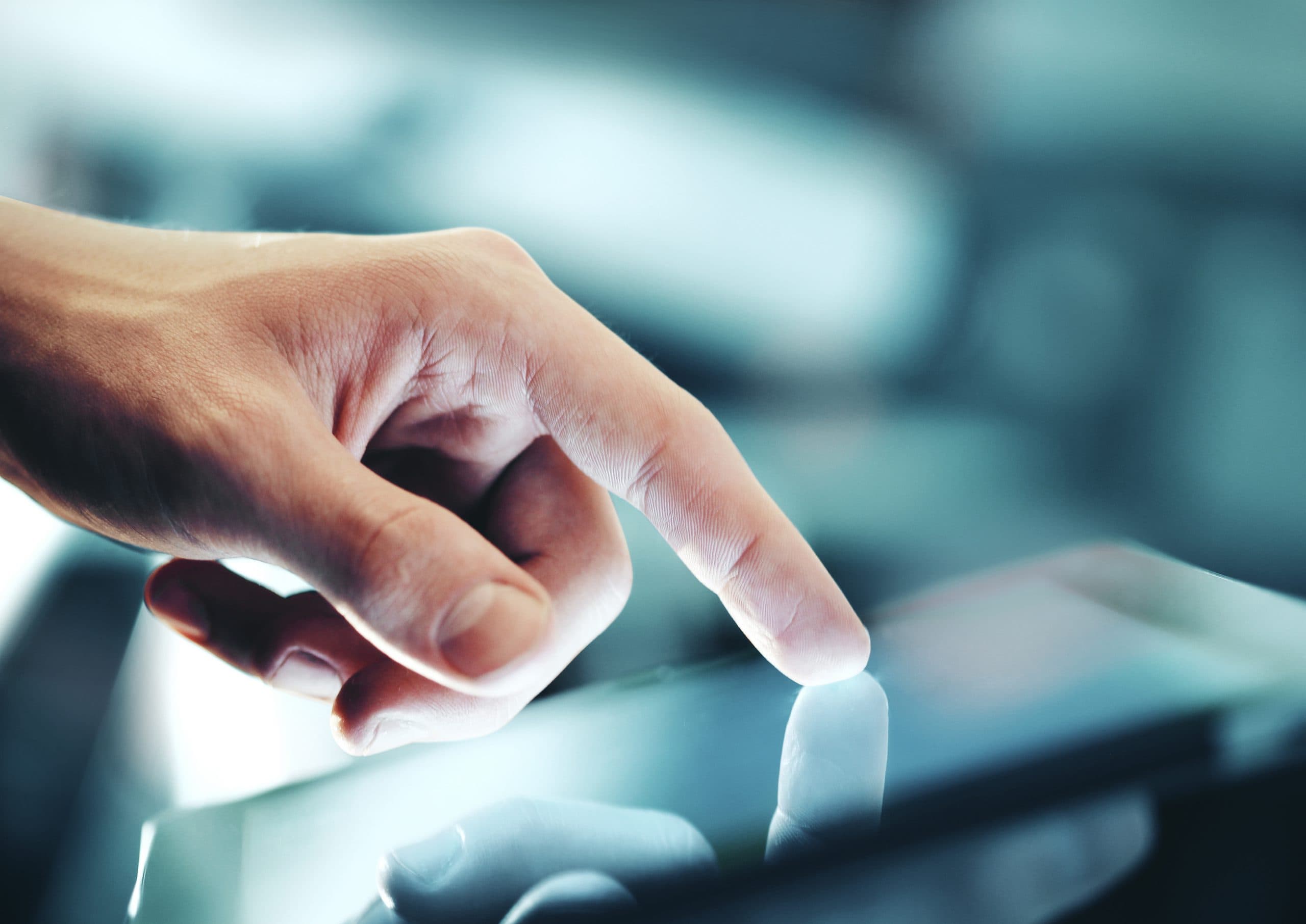 Hand die een verlicht touchscreen aanraakt, met reflectie op het glas en onscherpe digitale omgeving op de achtergrond.