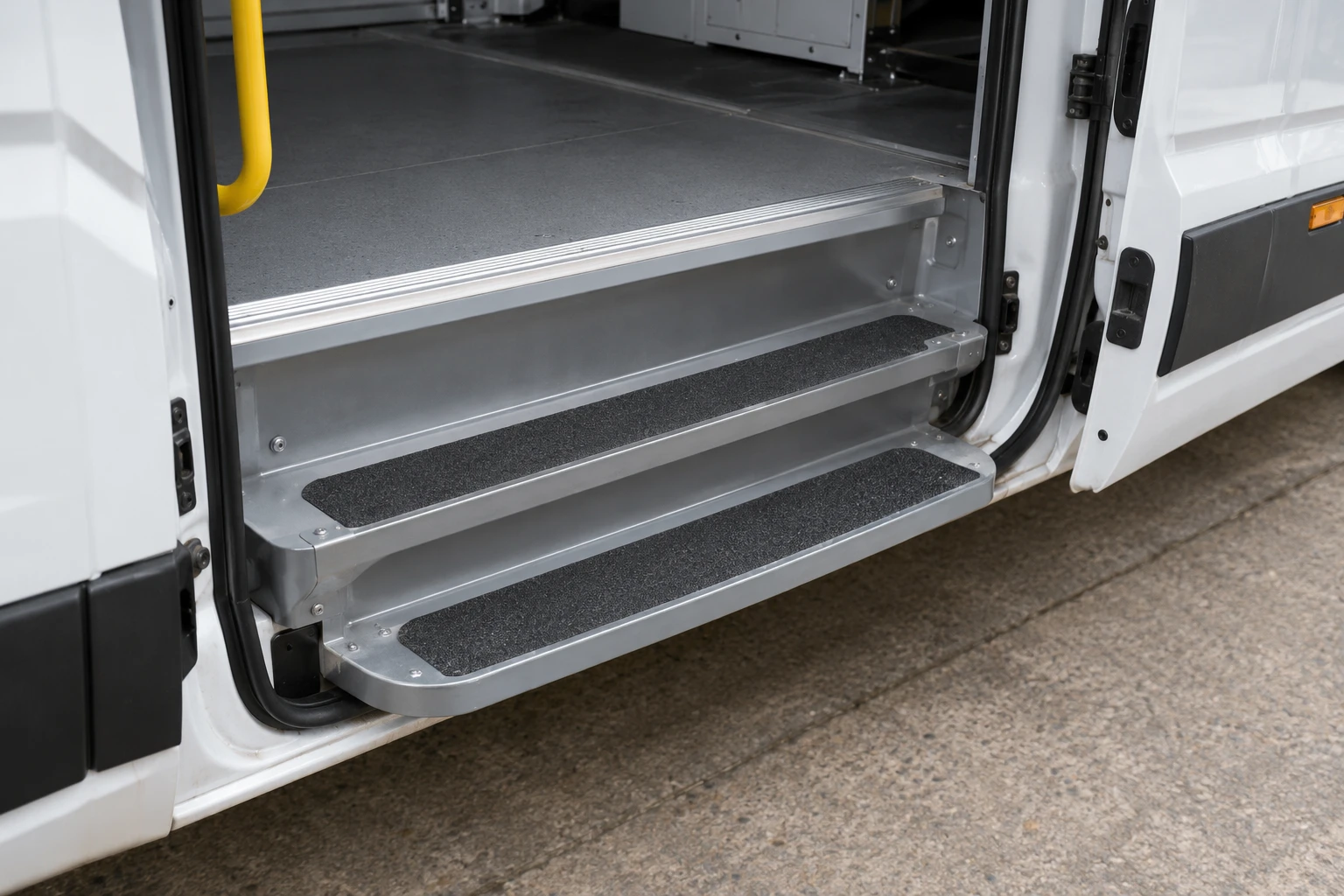 Black anti-slip strips on the metal access steps of a commercial vehicle