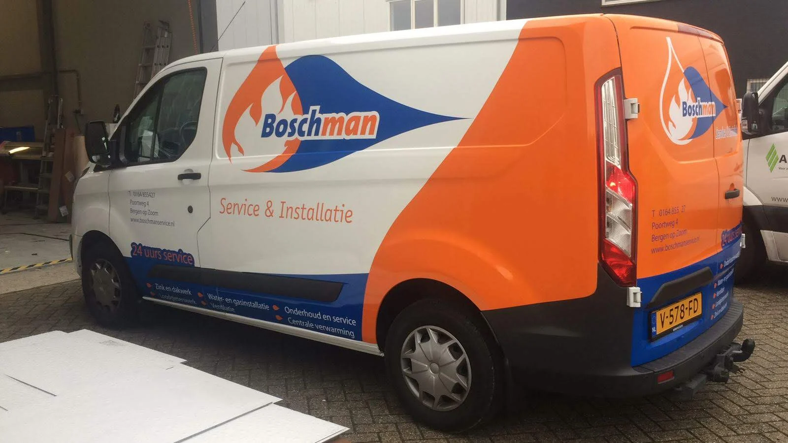 Ford van with orange and blue Boschman Service & Installatie graphics.