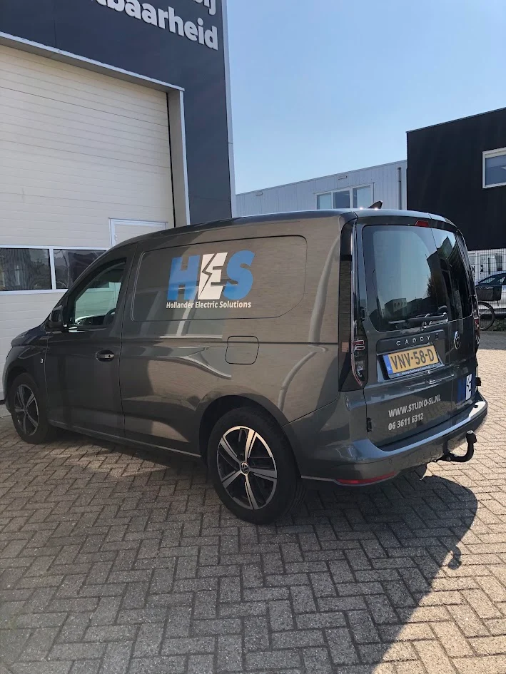 Grey Volkswagen Caddy with HES logo and contact details.