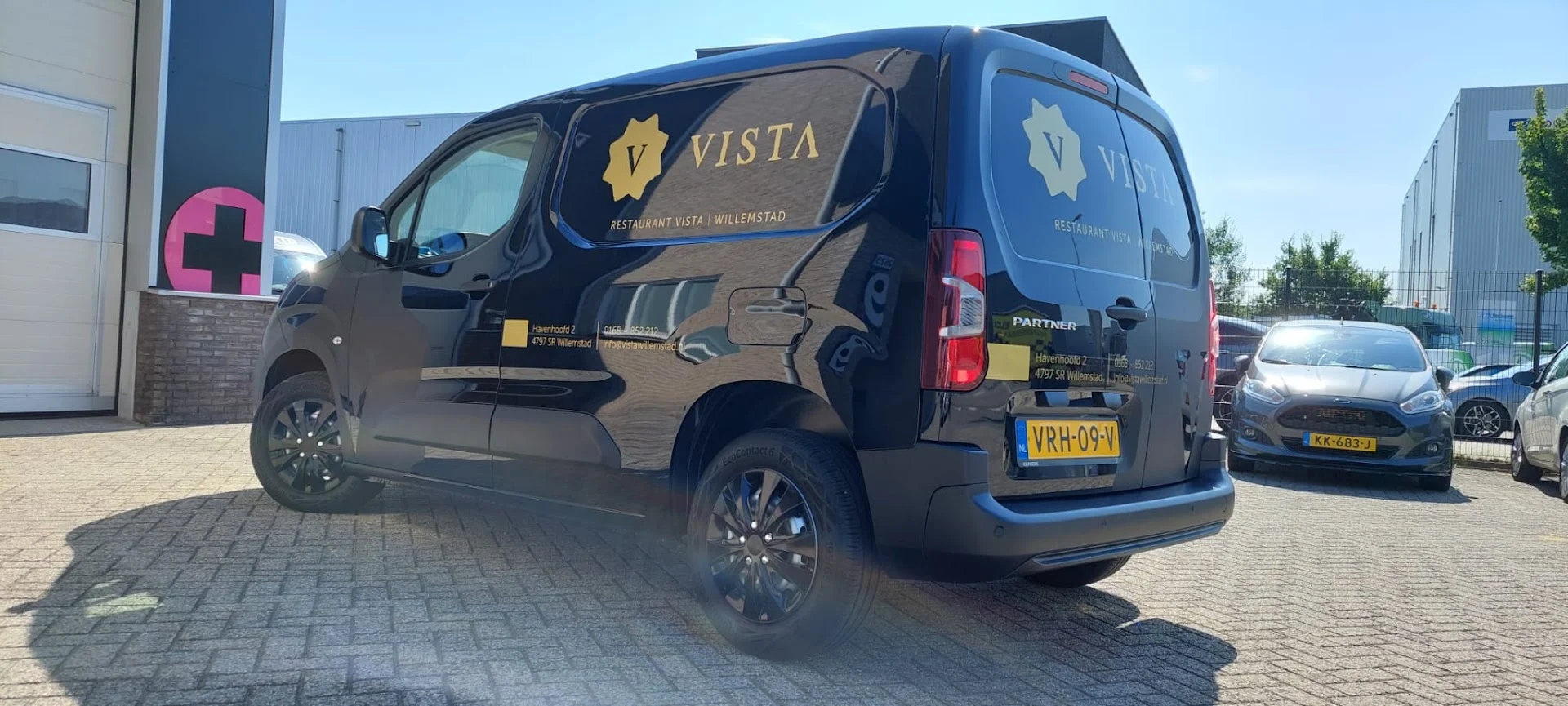 Vista van with a gold logo and contact graphics.