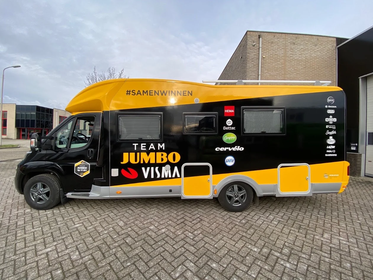 Jumbo-Visma motorhome with a yellow and black advertising wrap.