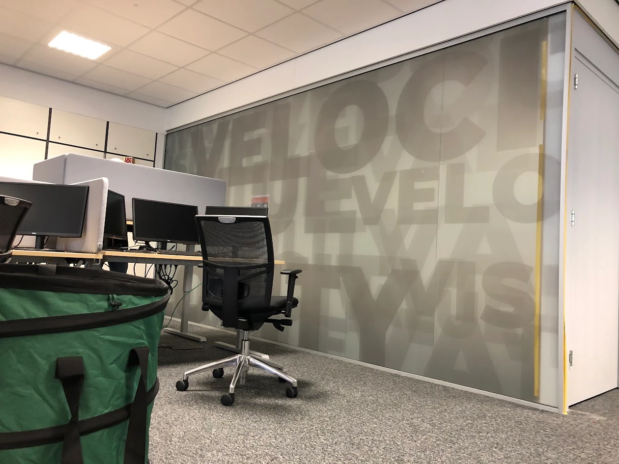 Office partition with a matt window print and large typographic shapes