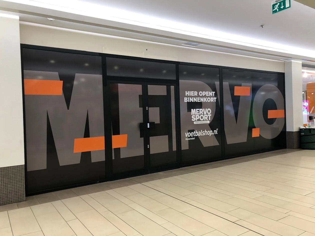 Opaque black and orange window graphics across a shopfront