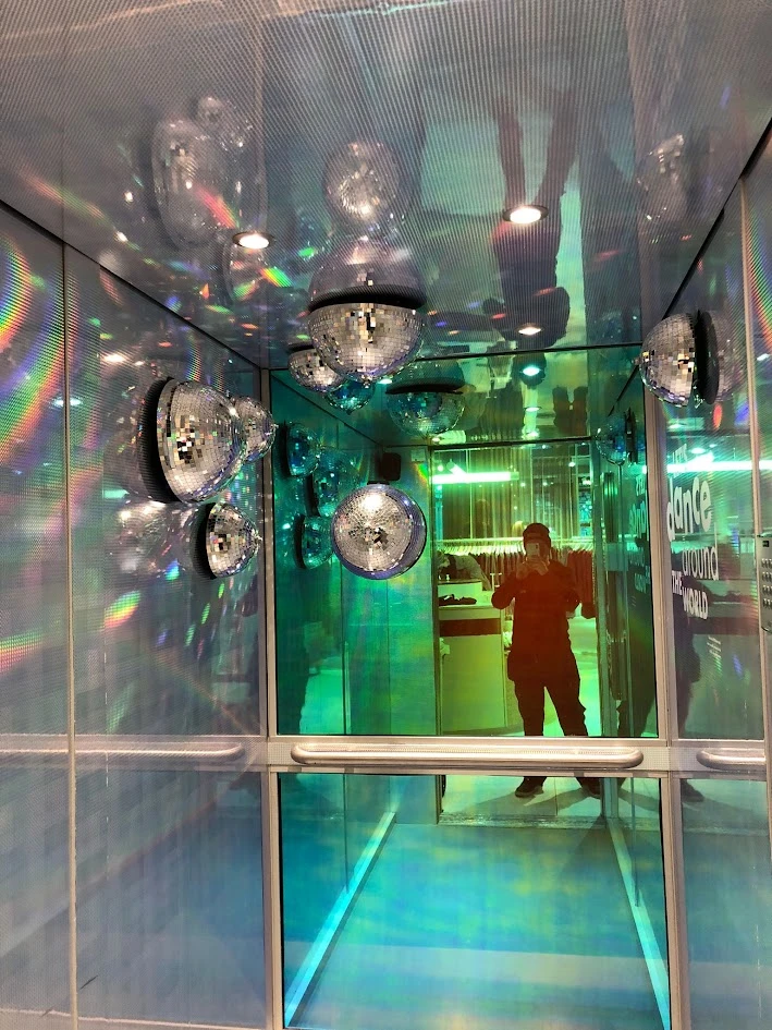Dichroic folie op spiegel in een lift, met gekleurde weerspiegelingen rond spiegelbollen
