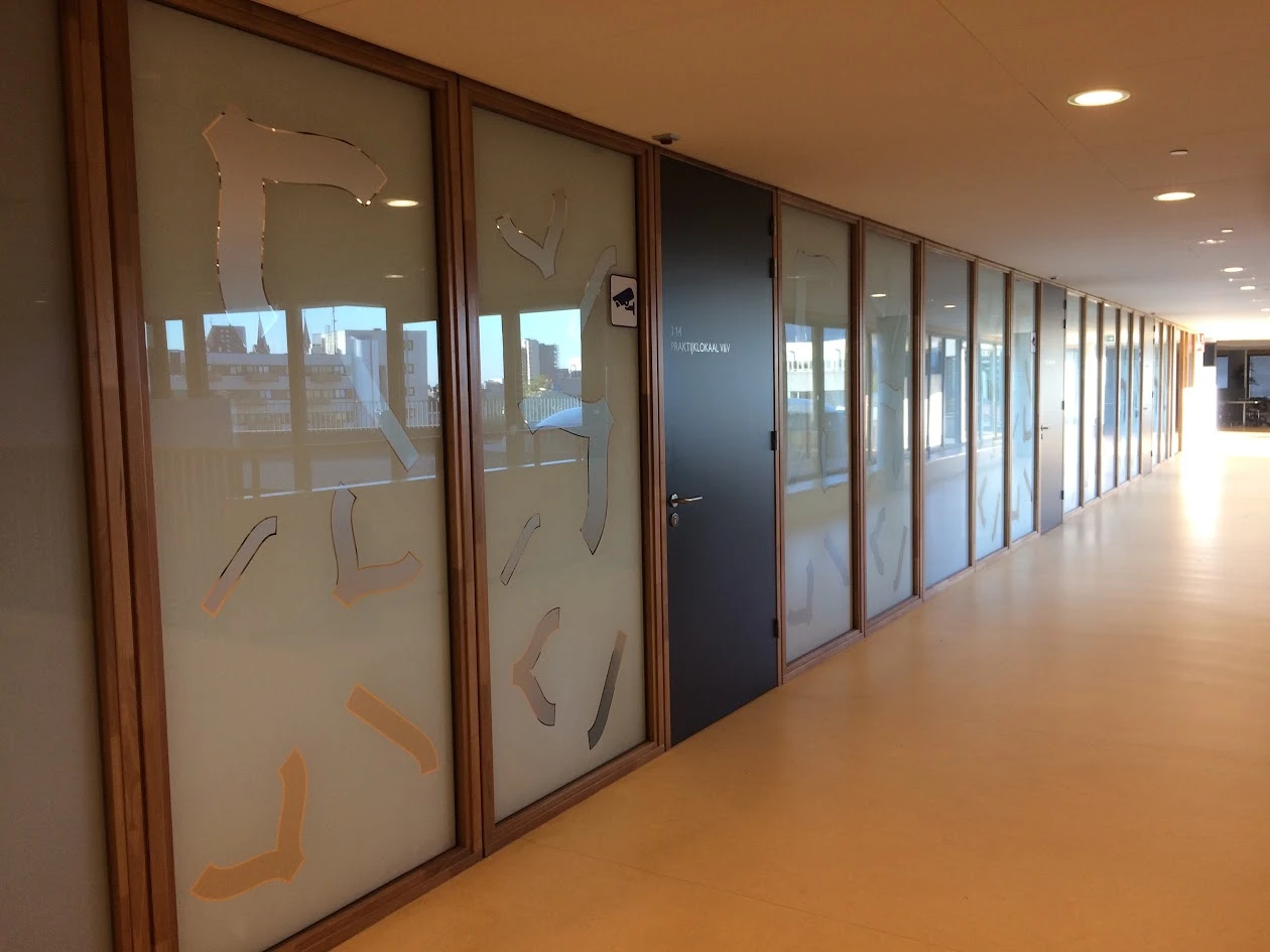 Long corridor with frosted window film and cut-out figures on glass