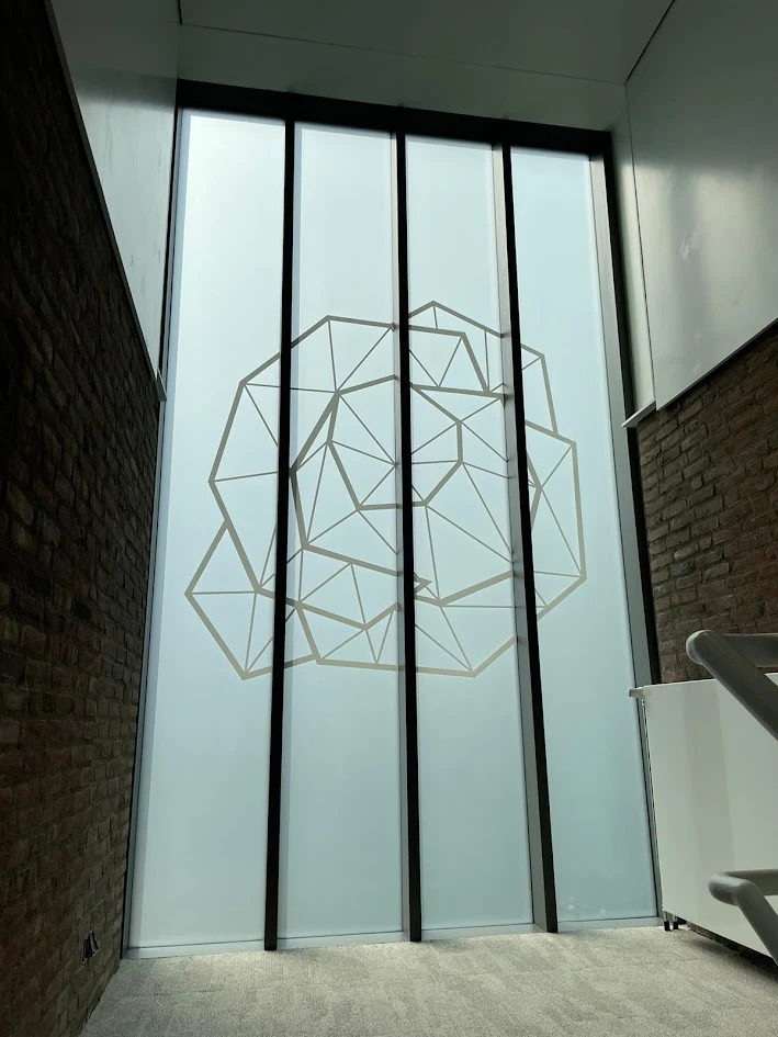 Tall glazed panels with frosted film and a printed geometric pattern