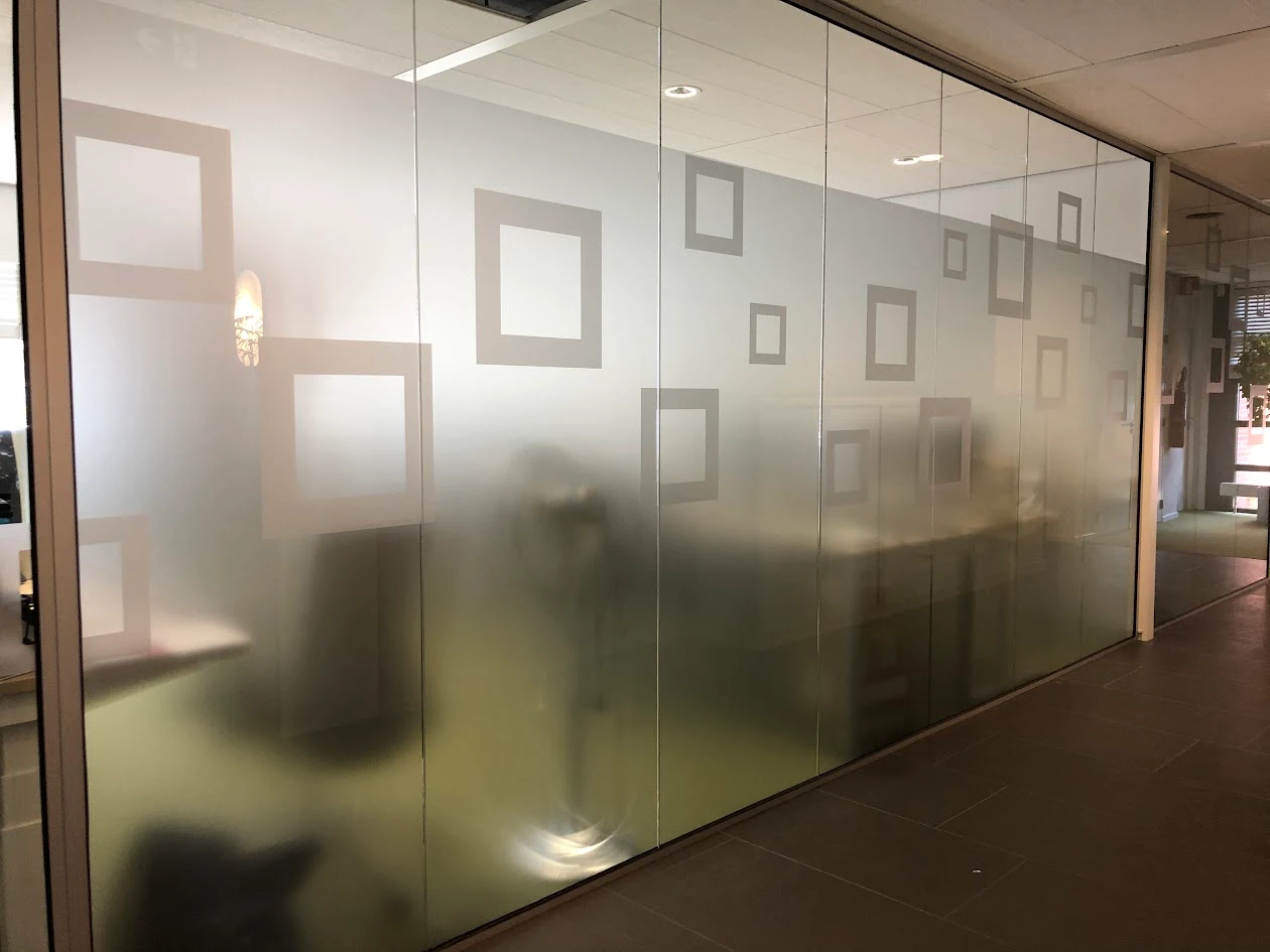Glass partition with frosted film and a decorative pattern of squares