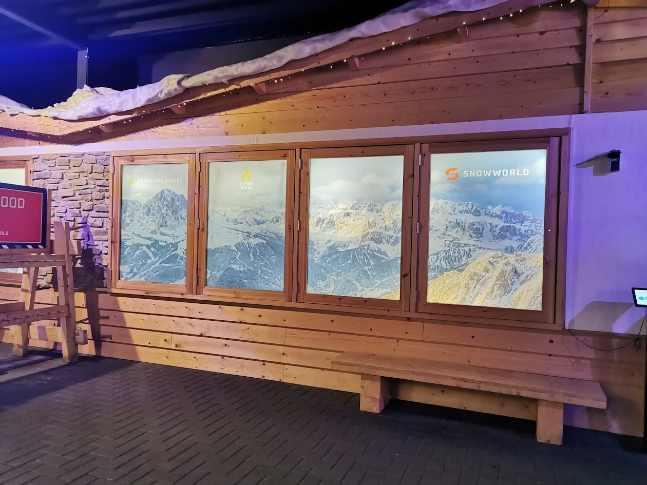 Printed windows with a mountain landscape and SnowWorld branding in a timber interior