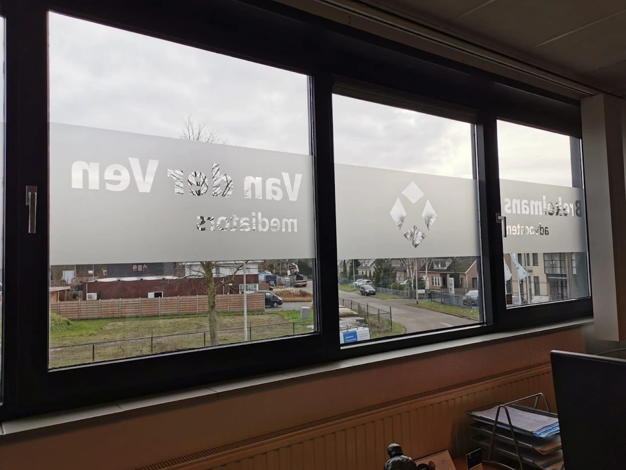 Names and a logo cut out of a frosted privacy band on office windows