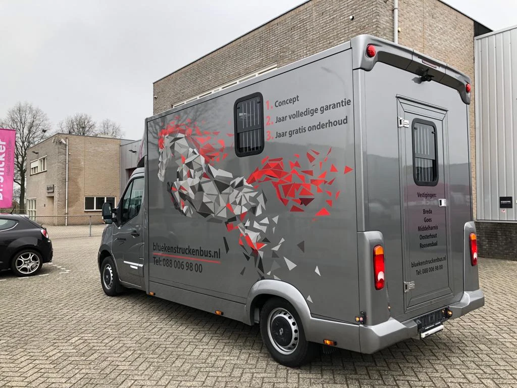 Side and rear of a grey horsebox with a geometric horse graphic
