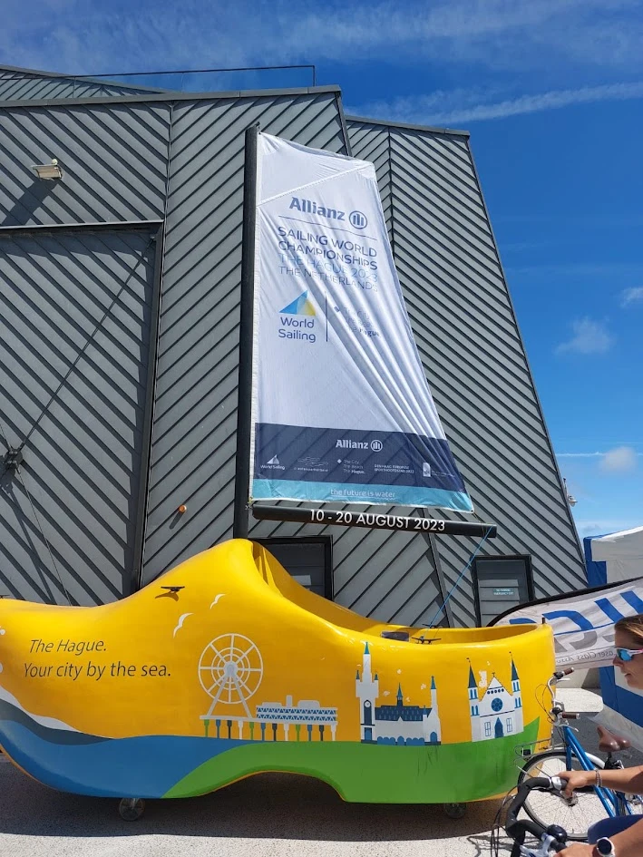 Yellow promotional vehicle with a colourful skyline of The Hague