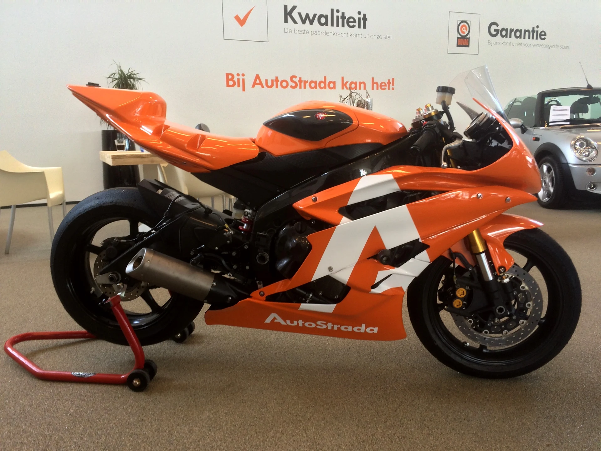 Orange racing motorcycle with white AutoStrada graphics