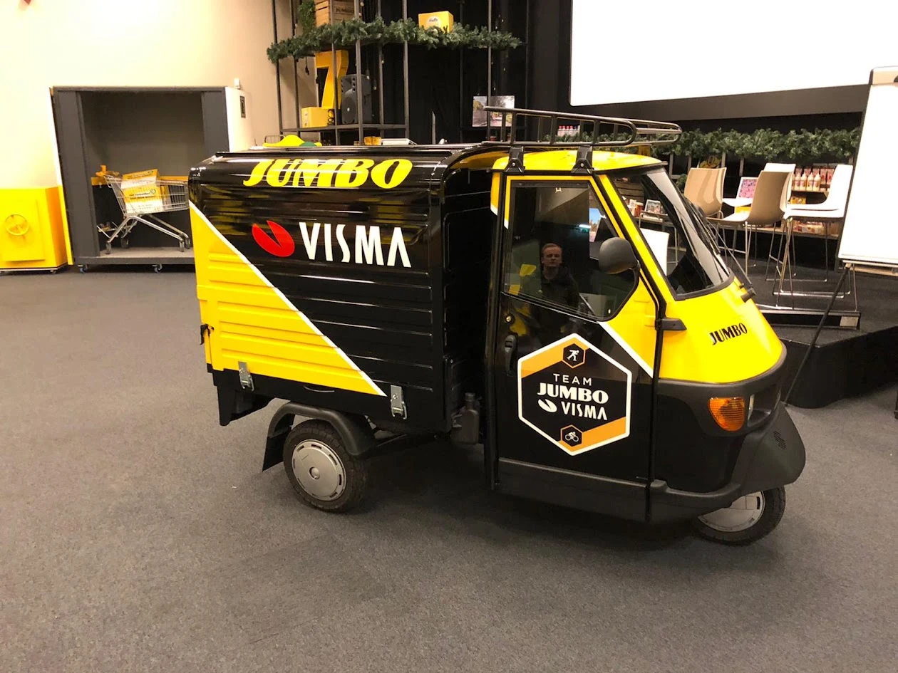 Yellow and black tuk-tuk with Team Jumbo-Visma graphics