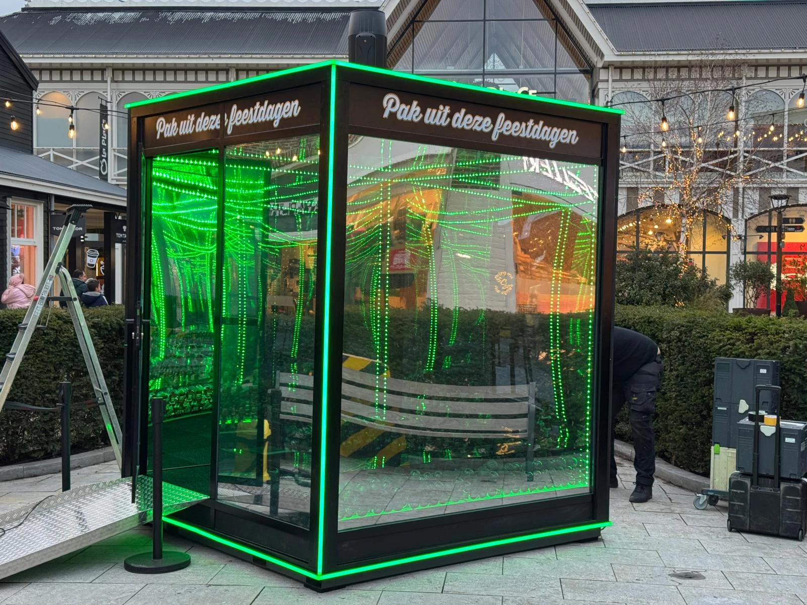 Lichtinstallatie met spiegelende vlakken en herhaalde groene lichtlijnen