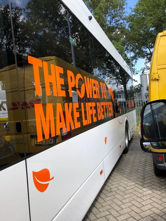 Detail of orange campaign lettering on a BYD bus