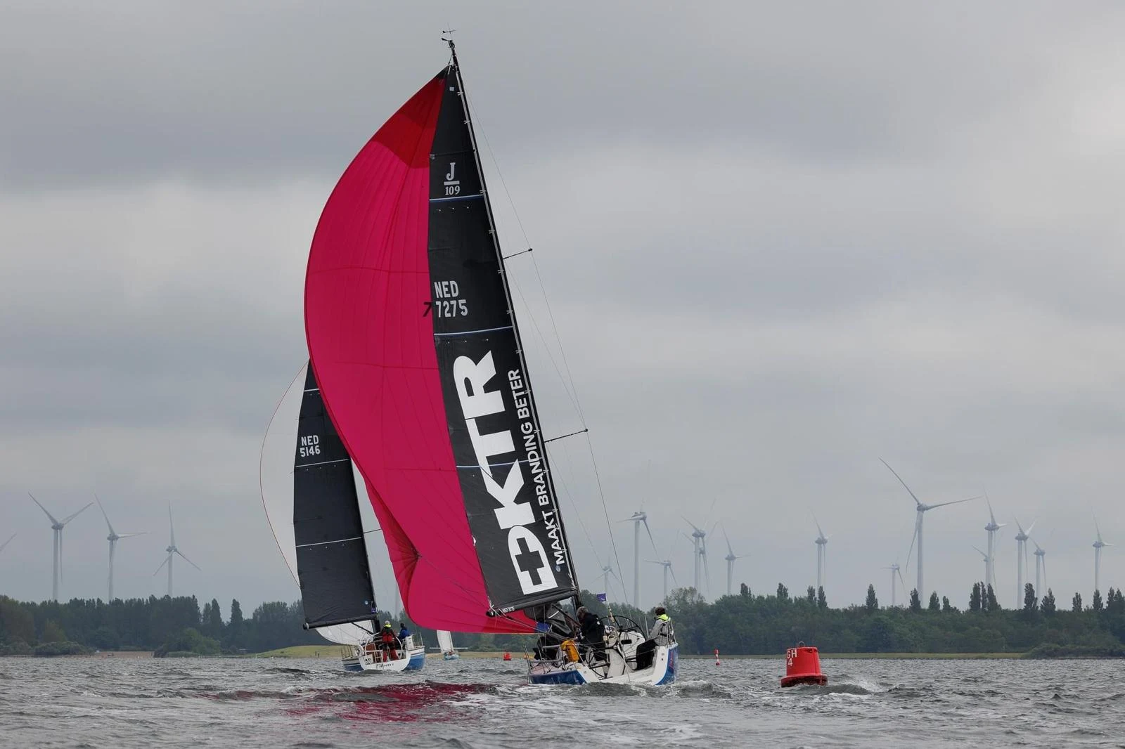 Sailing yacht with large white DKTR lettering on its dark mainsail